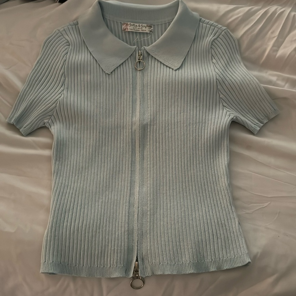 Pastel blue, short sleeve t-shirt with a zip down the whole middle,size medium
